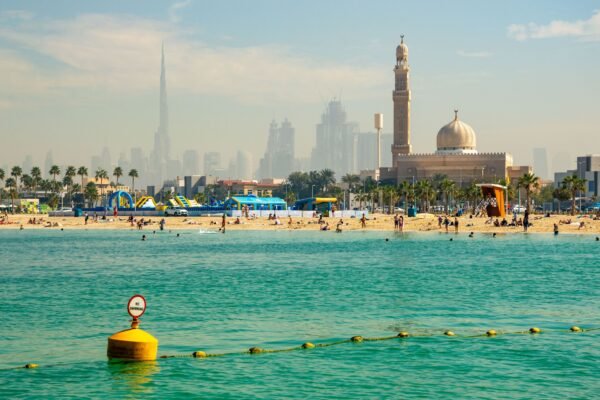 Strand met moskee en skyline in Dubai
