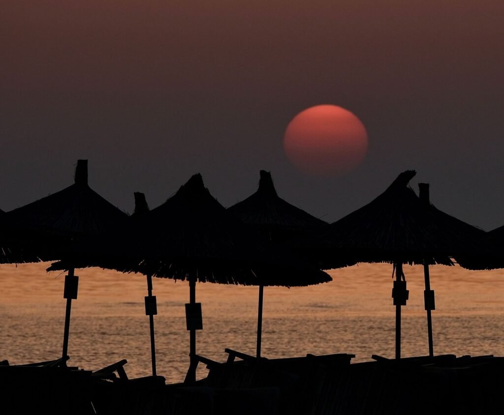 Parasols bij zonsondergang in Durrës