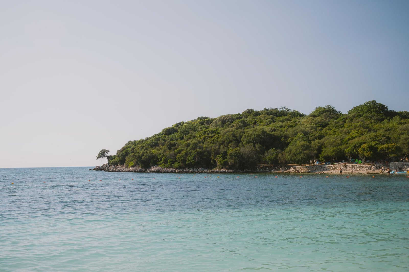 Strand van Ksamil met helder water en een groen eilandje