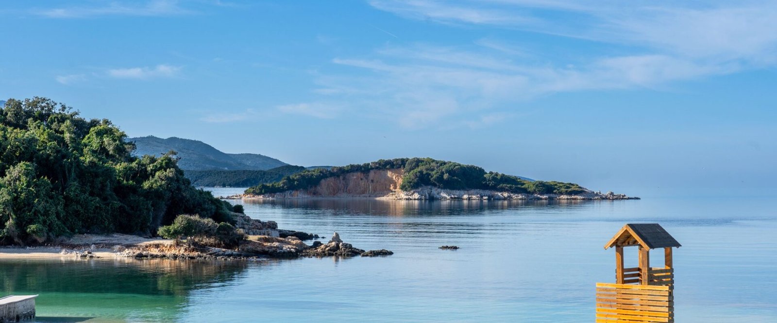 Strand met helder water en groen bij Ksamil