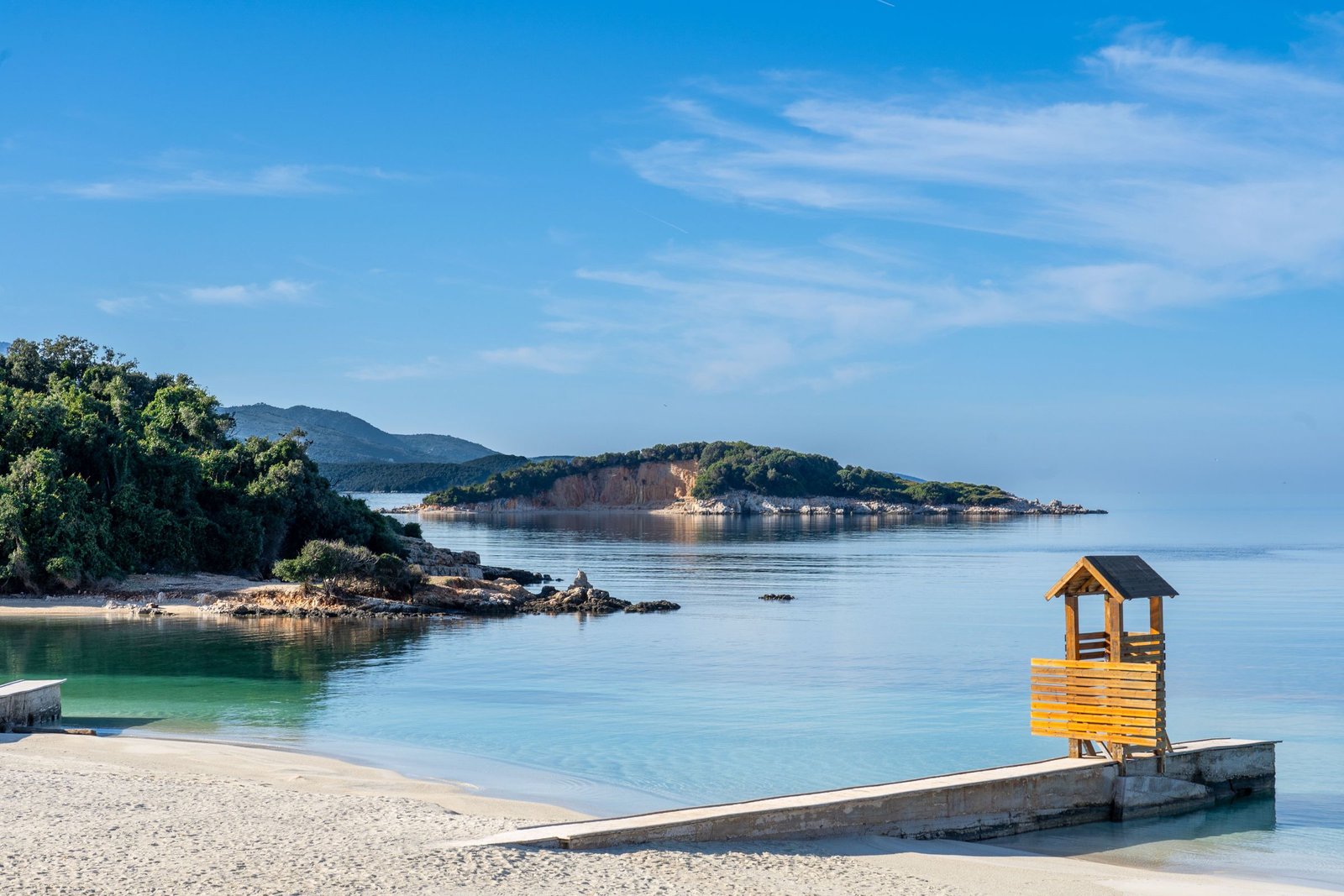 Strand met helder water en groen bij Ksamil