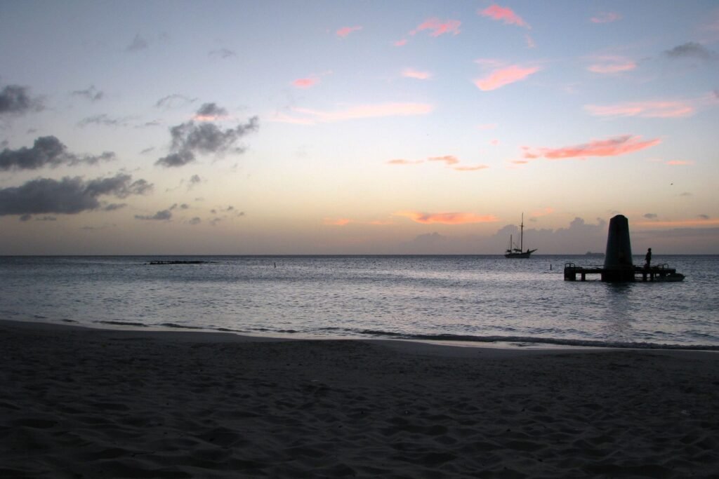 Schemering boven een strand met pier op Aruba