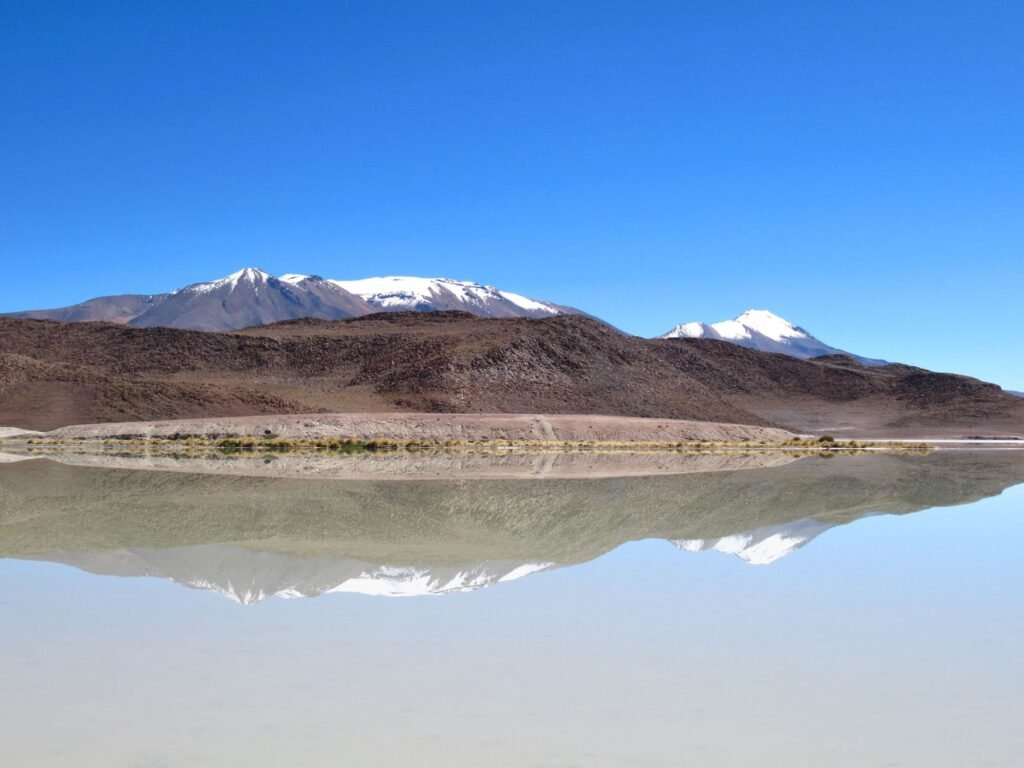 Besneeuwde vulkanen weerspiegeld in een lagune in Bolivia