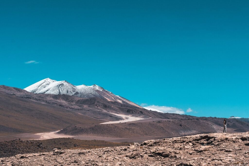 Besneeuwde vulkaan boven de hoogvlakte bij Uyuni
