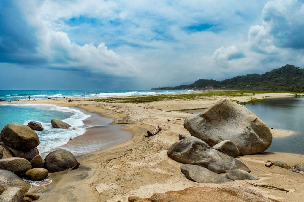 Granieten rotsblokken en palmen aan een strand in Tayrona National Park