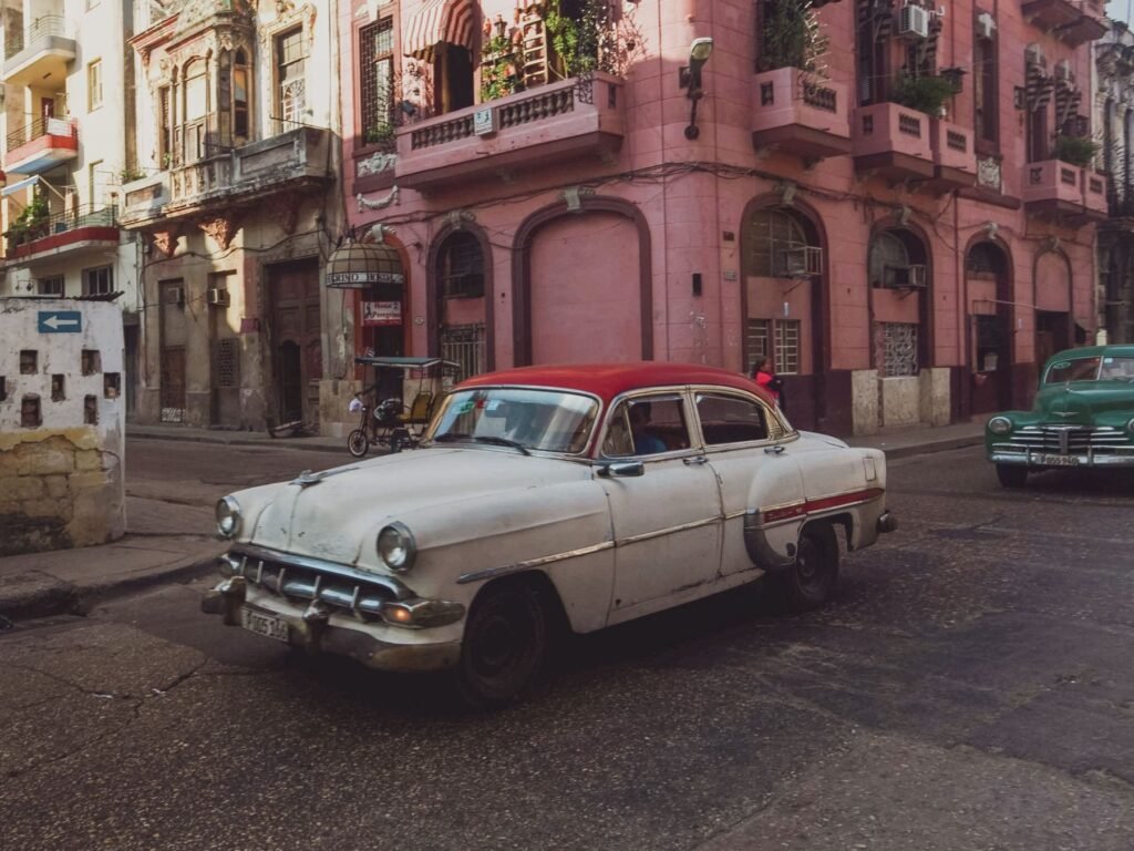 Roze gevels en een klassieke auto in Havana