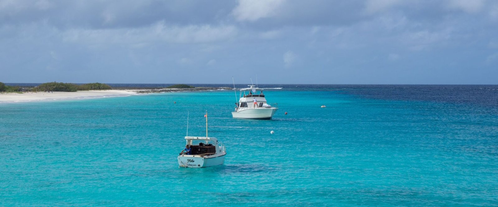Twee boten op turquoise water bij Curaçao