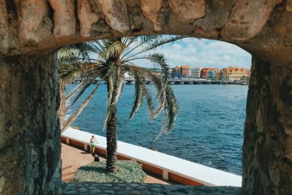Doorkijk door een stenen boog naar het water in Willemstad