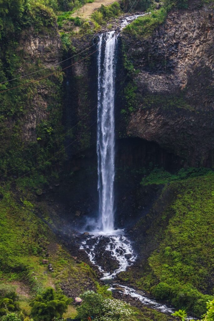 Hoge waterval tussen groene rotswanden in de Ecuadoraanse Andes