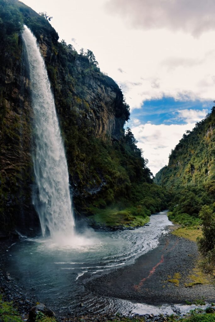 Waterval die in een rivier stort tussen de bergen