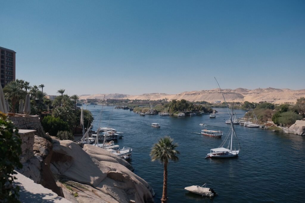 Nijl met boten en palmbomen bij Aswan