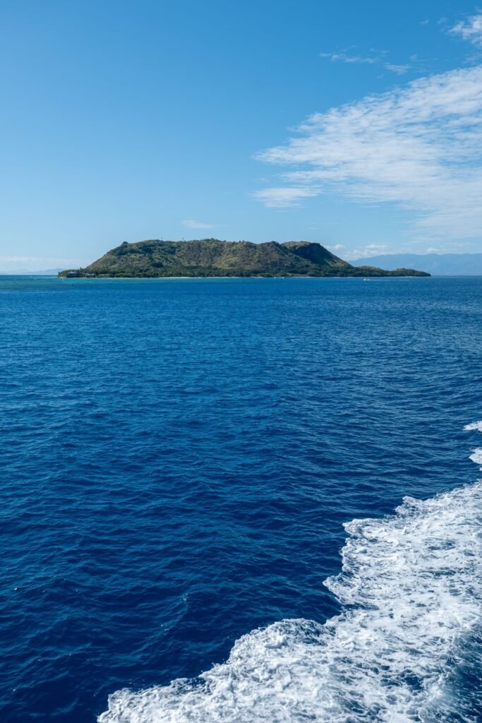 Uitzicht vanaf de boot op een groen eiland in Fiji