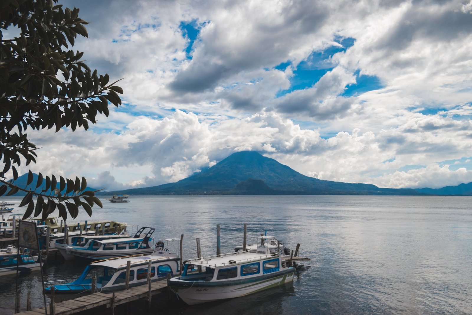 Boten aan de oever van het Lago de Atitlán met een vulkaan