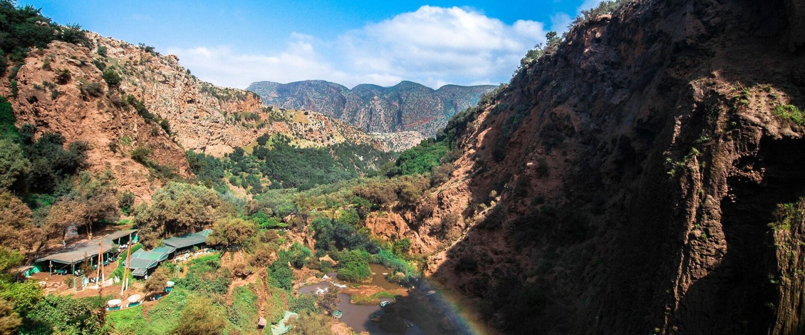 Groene kloof met een regenboog bij de watervallen in de Midden-Atlas