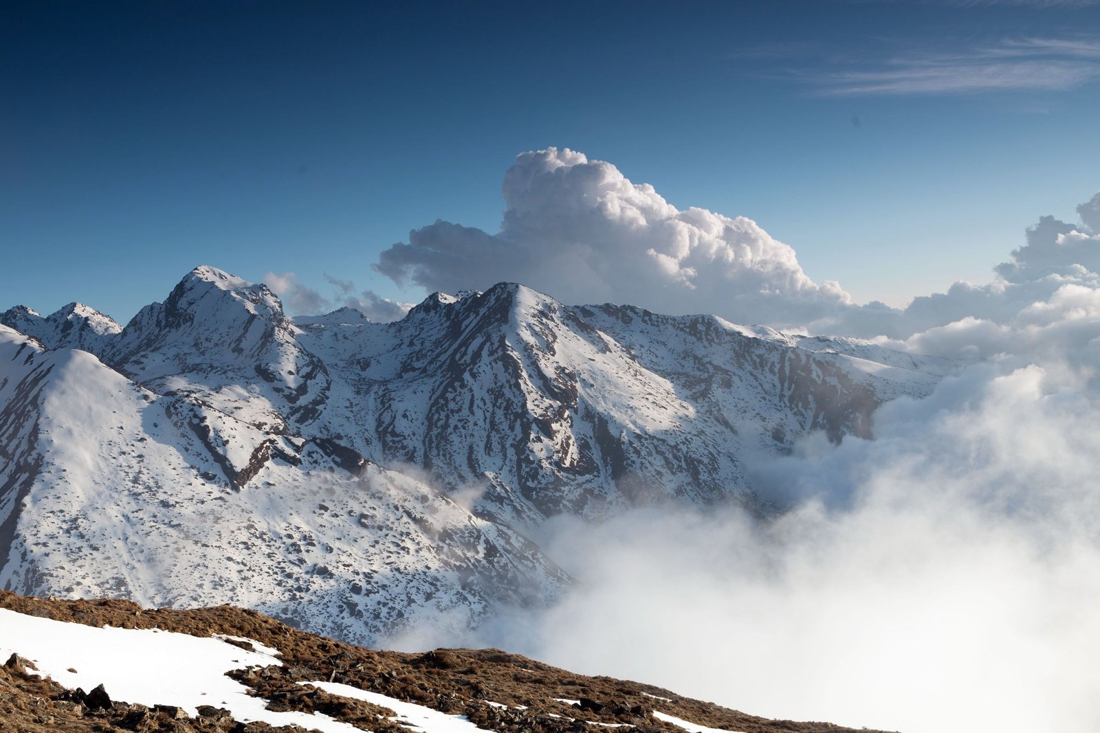 Besneeuwde toppen van de Hoge Atlas rond de Toubkal boven de wolken