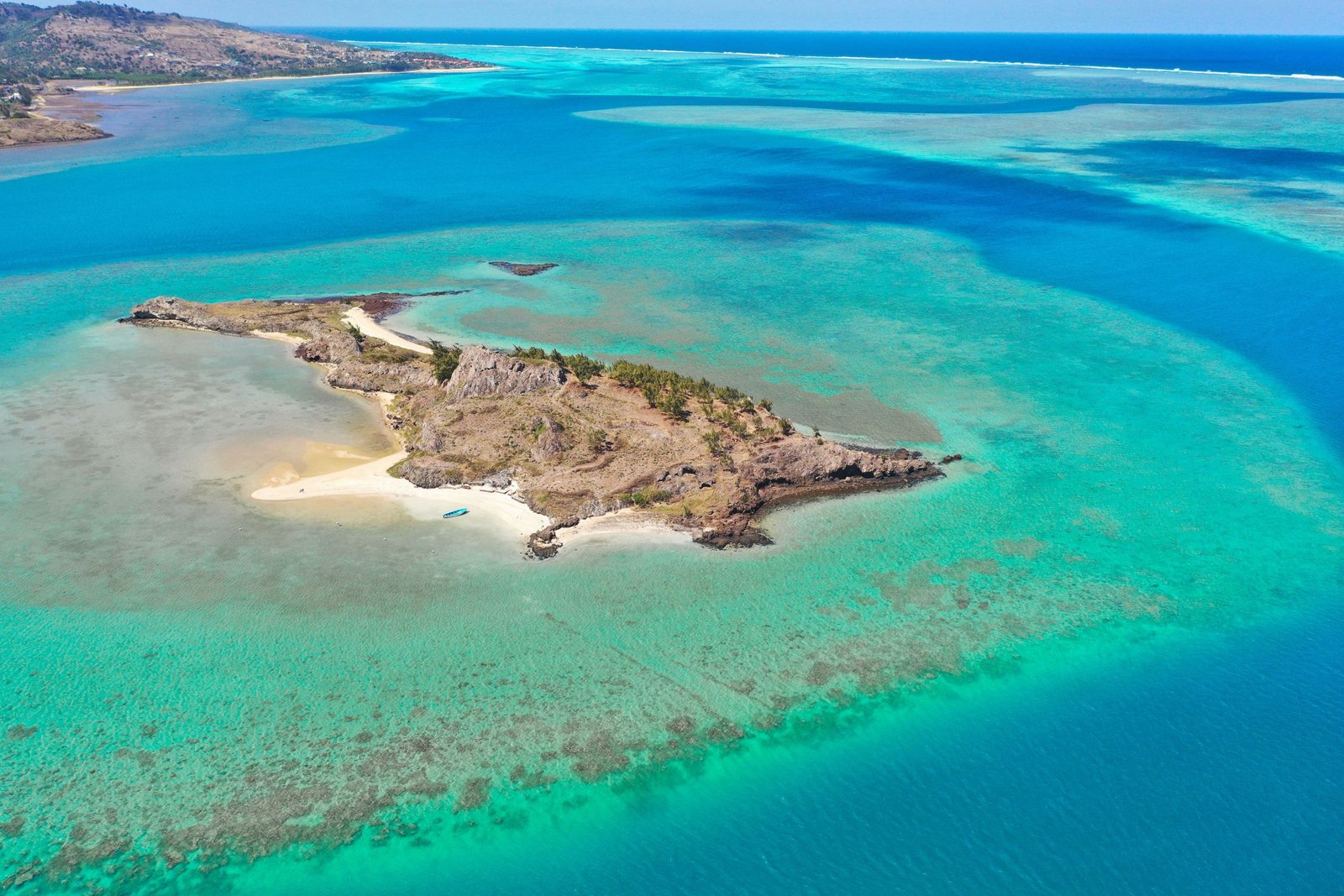 Luchtfoto van een eilandje met rif en turquoise water bij Nosy Be