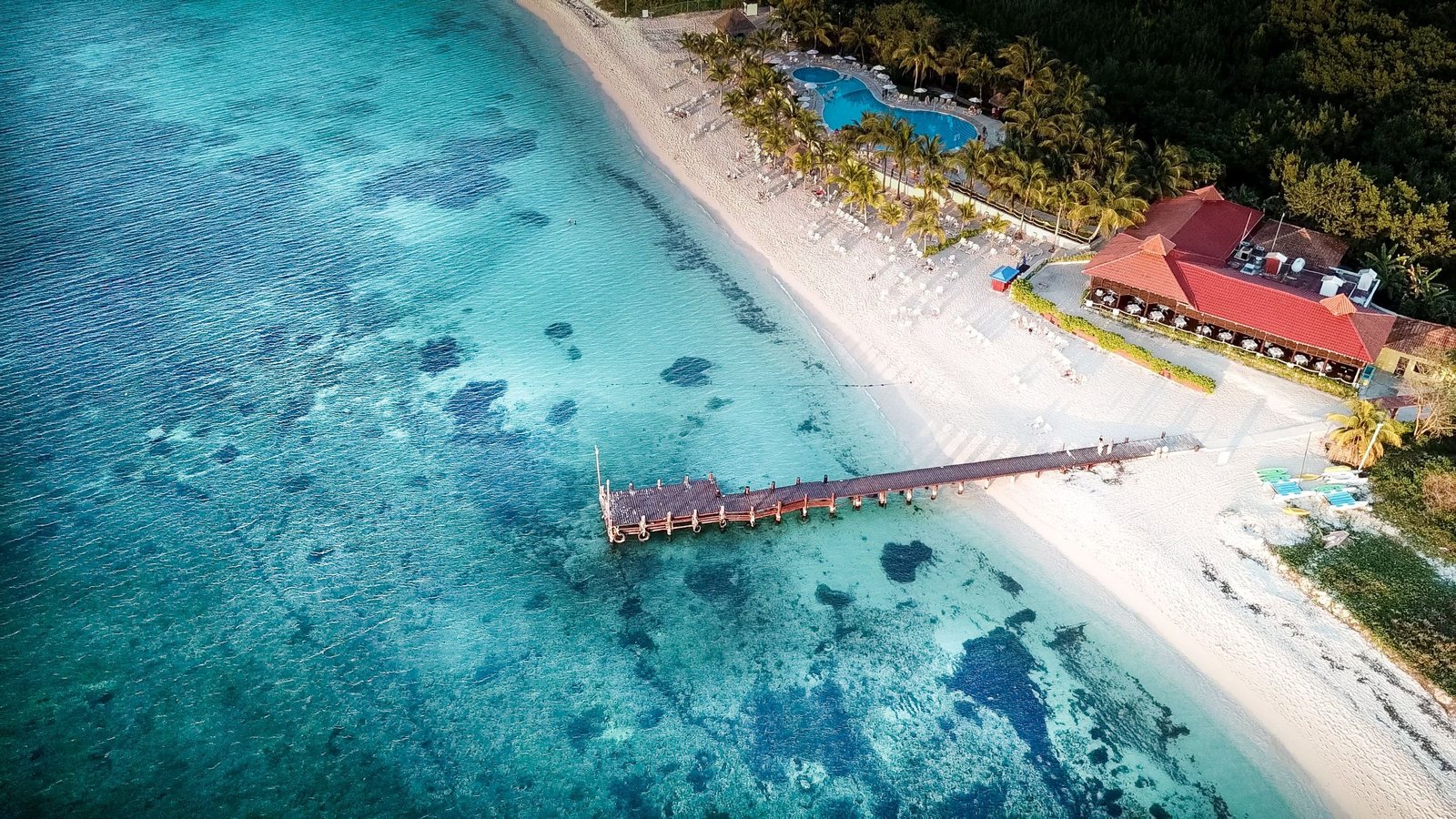 Strand met pier en turquoise water op Cozumel