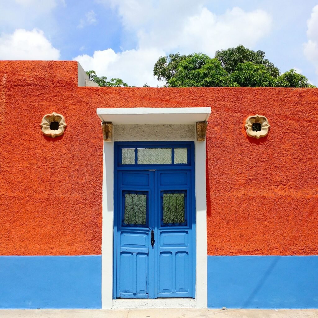 Oranje gevel met blauwe deur in Mérida