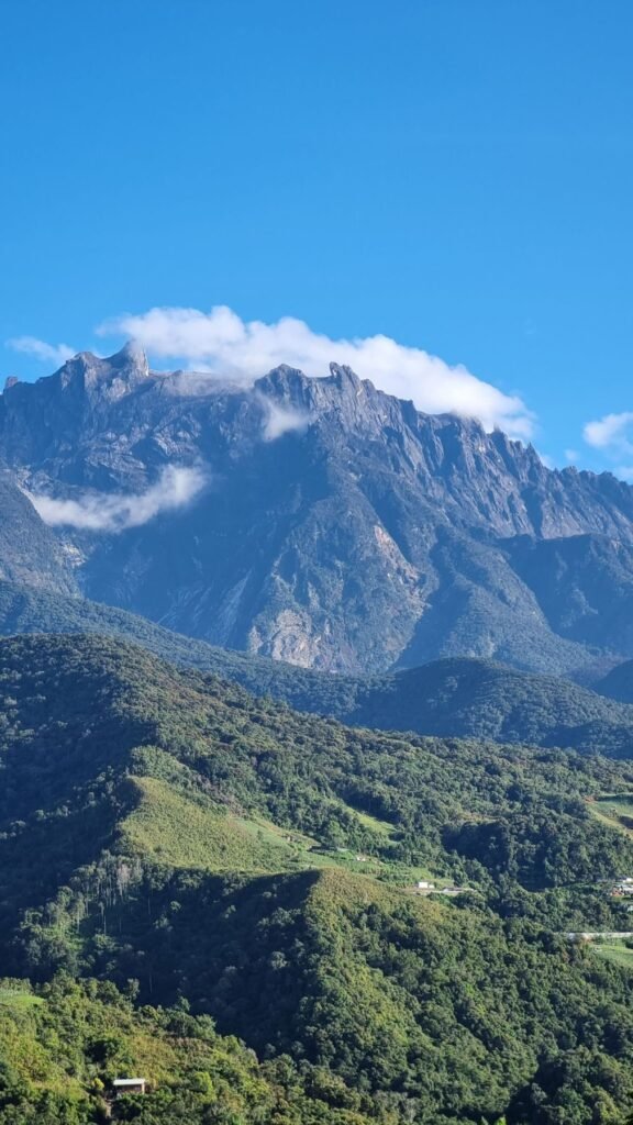 Mount Kinabalu boven groene heuvels in Sabah