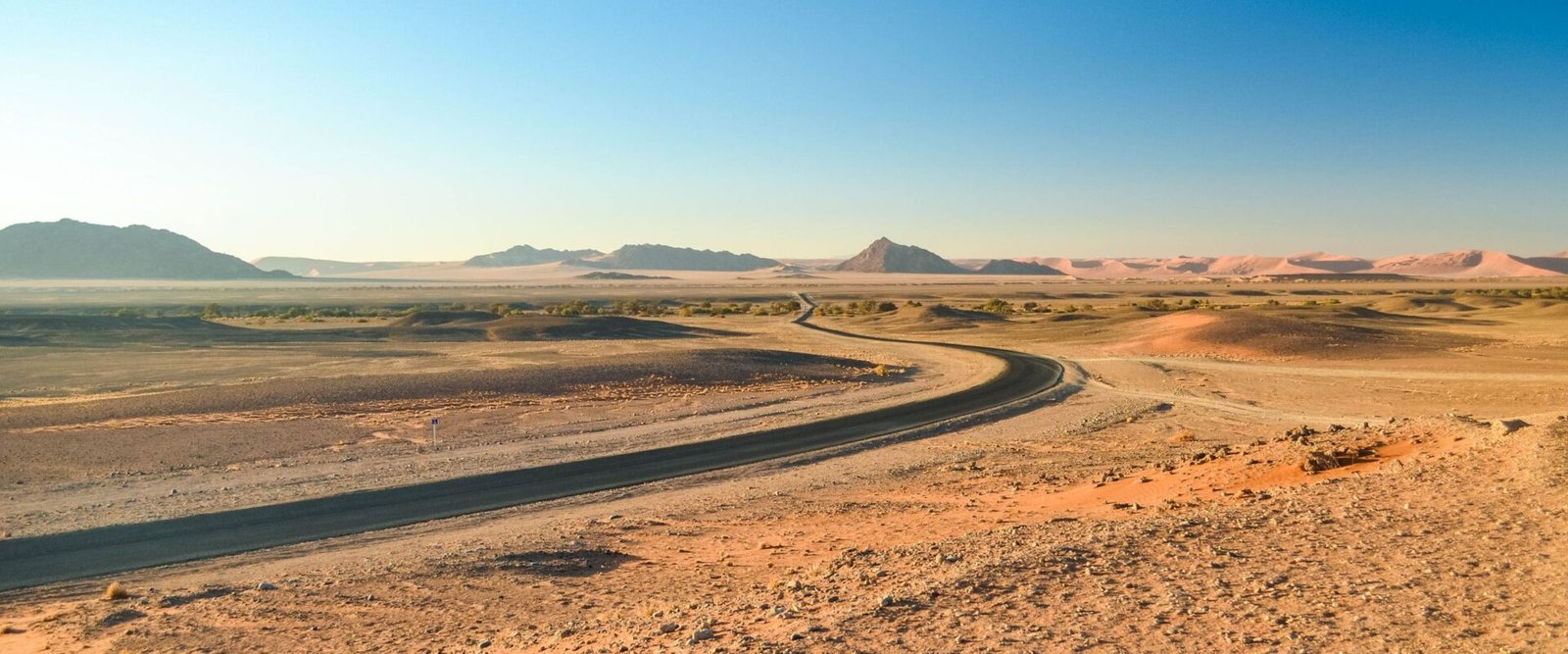 Weg door een open woestijnlandschap in Namibië