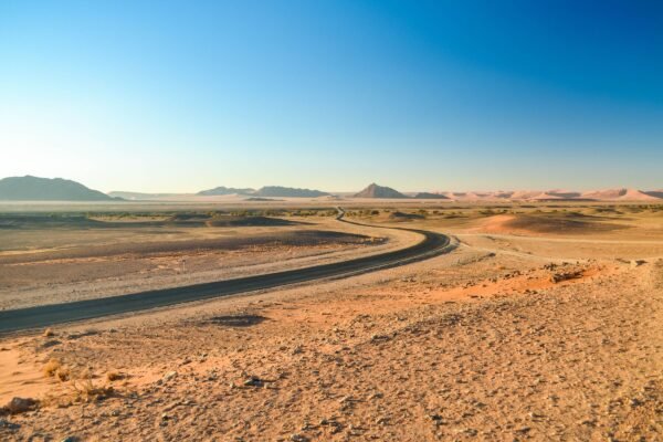 Weg door een open woestijnlandschap in Namibië