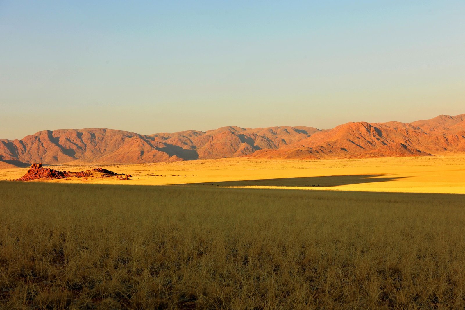 Gouden grasvlakte voor een bergketen in het hoogland van Namibië