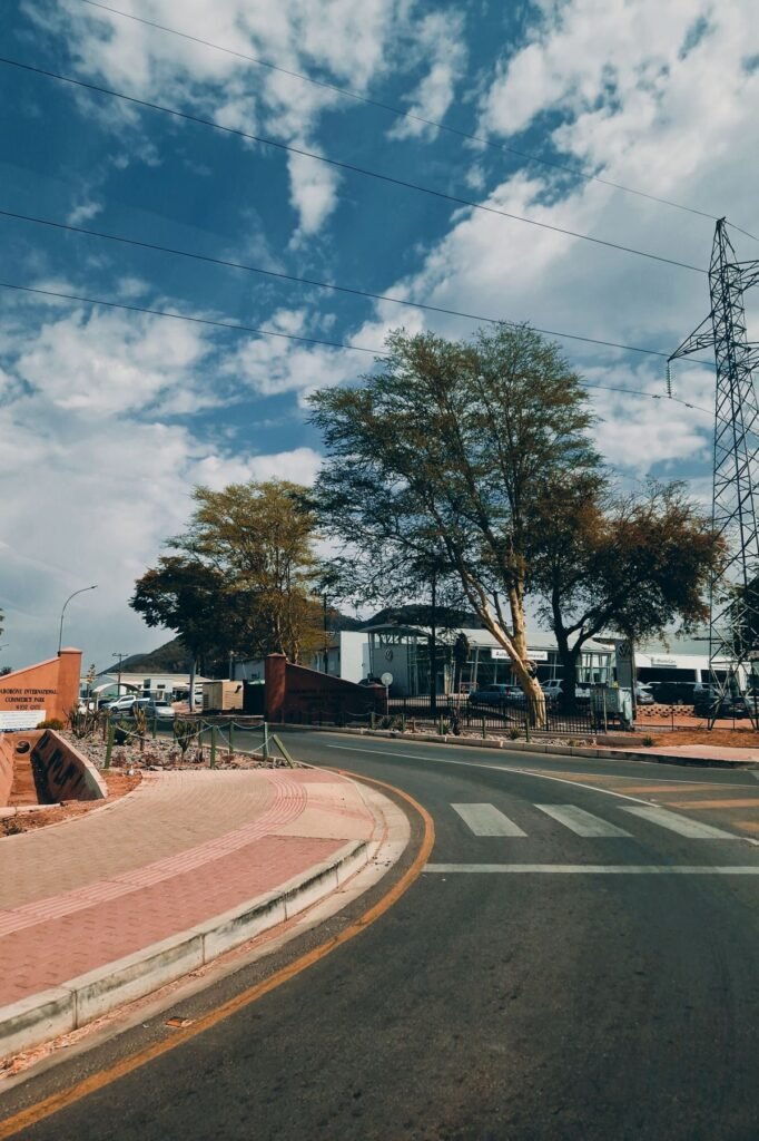 Rechte asfaltweg door de savanne bij zonsopkomst in de buurt van Windhoek