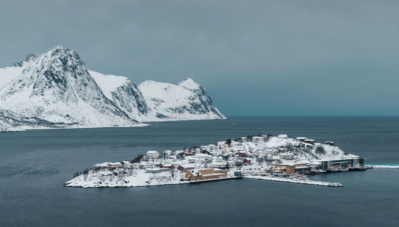 Besneeuwde bergen en eiland aan de Noorse kust