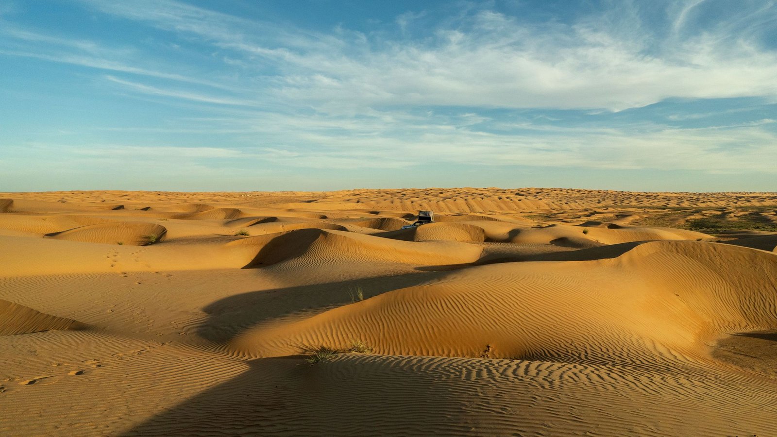 Gouden duinen onder een blauwe lucht