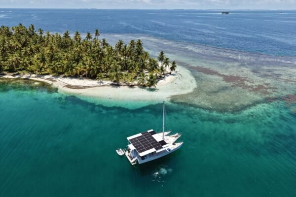 Catamaran voor anker bij een palmeiland in San Blas, van bovenaf