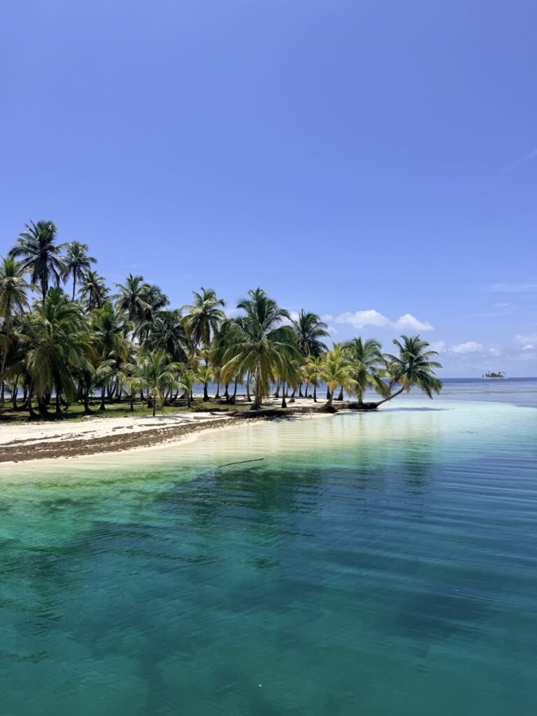 Klein eiland met palmbomen en een zeilboot in de San Blas-eilanden