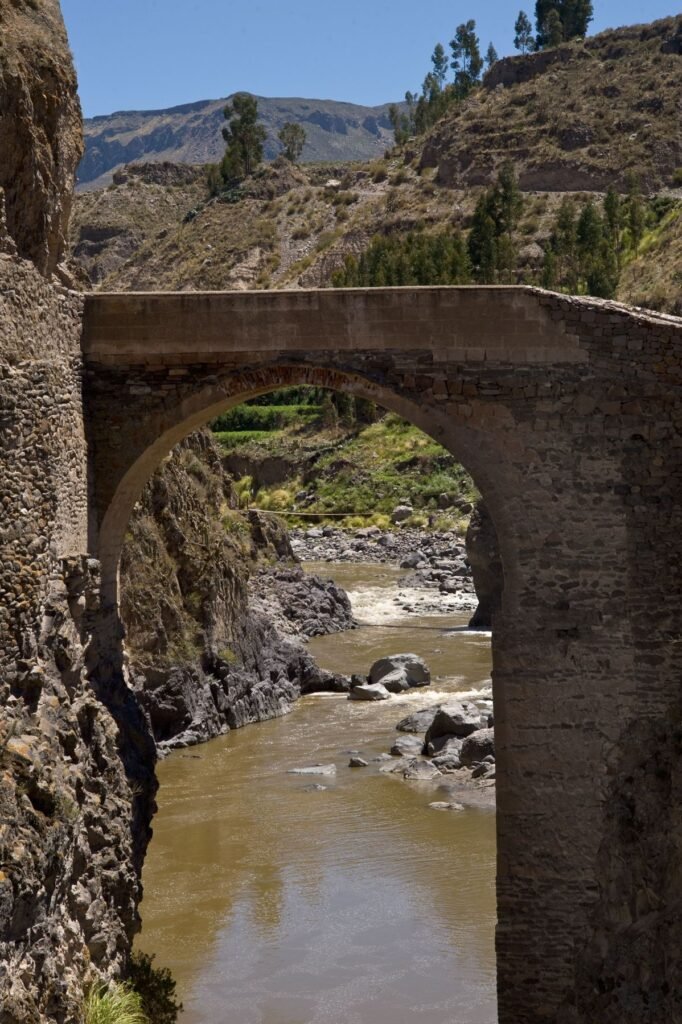 Dorp met een witte koloniale kerk in de Colca-vallei, met bergen op de achtergrond
