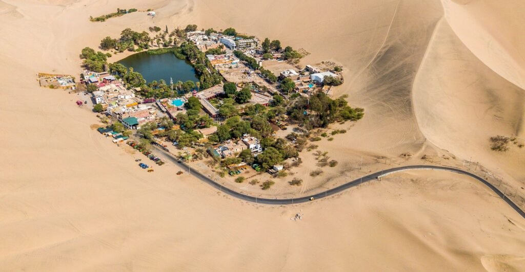De oase van Huacachina van bovenaf, omringd door zandduinen