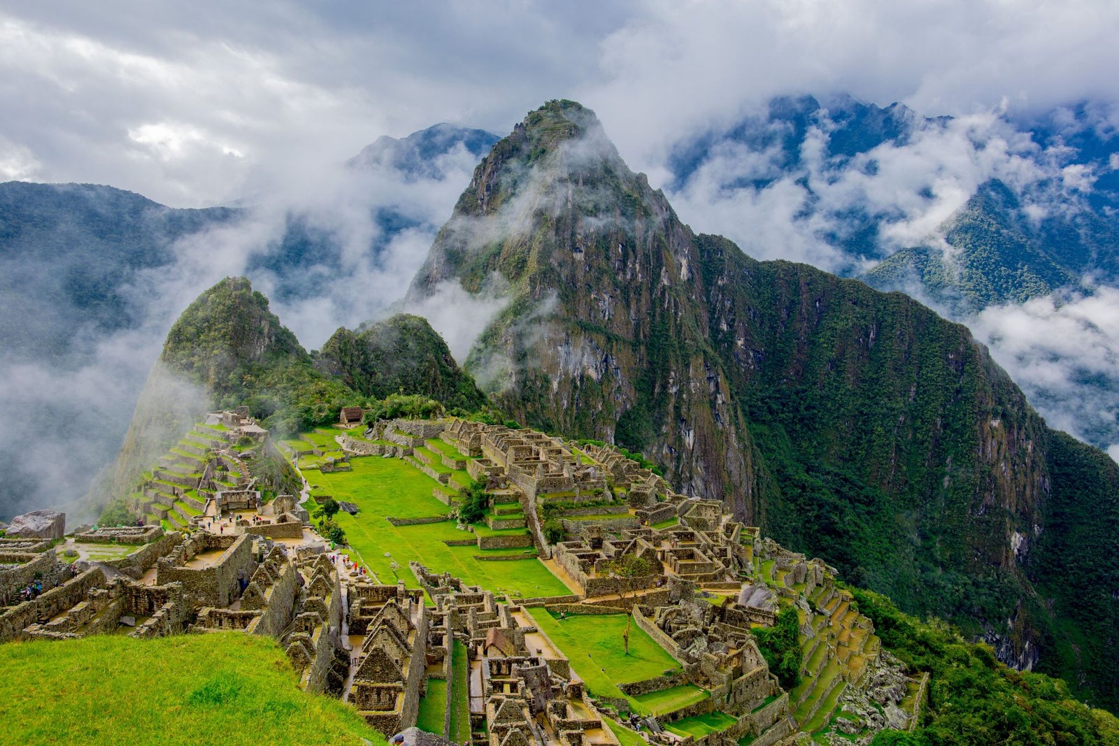 De ruïnes van Machu Picchu tussen wolken en groene bergen
