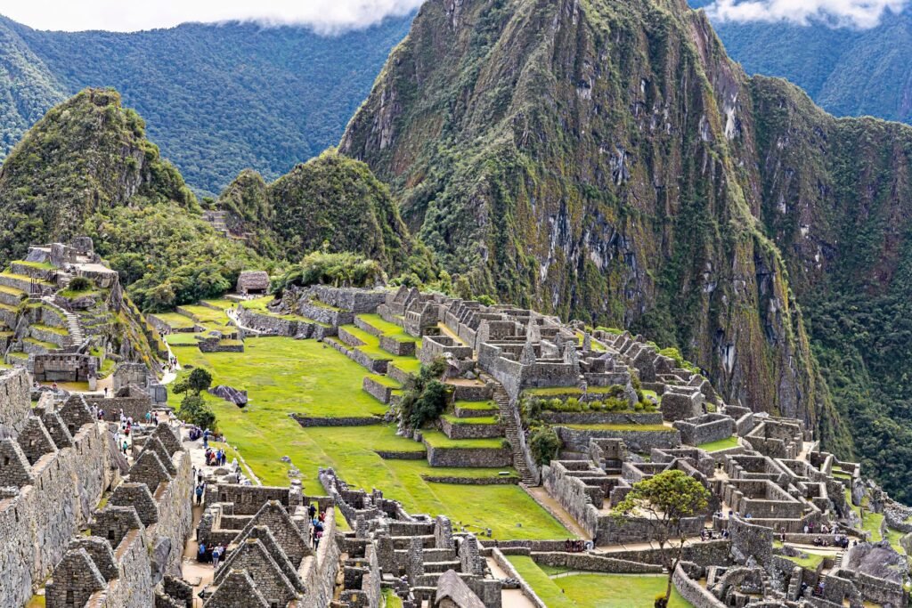 De steile groene top van Huayna Picchu boven de ruïnes