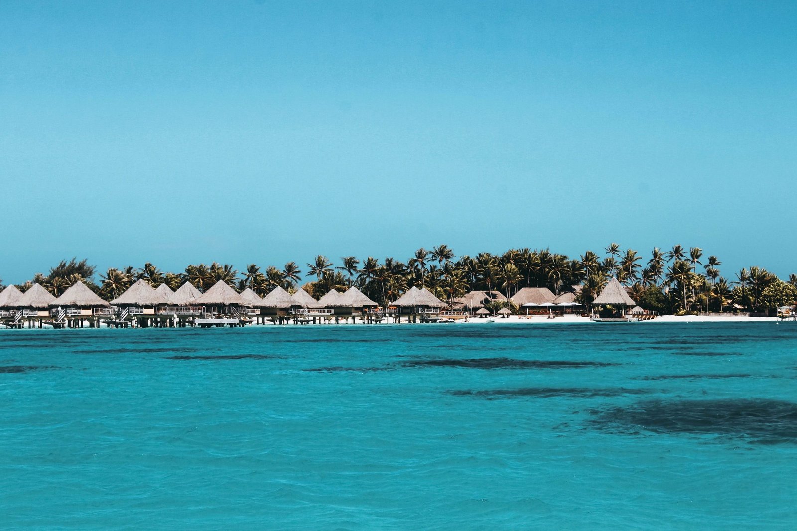 Bungalows op palen in het turquoise water van Frans-Polynesië