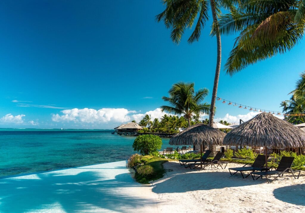 Strand met palmbomen en rieten hutten in Frans-Polynesië