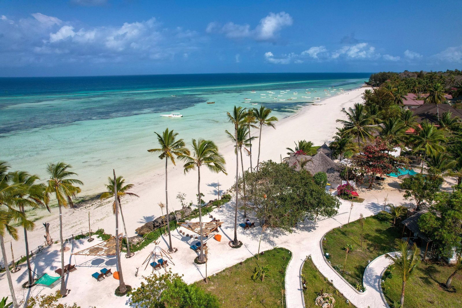 Wit strand met palmbomen langs de kust van Zanzibar vanuit de lucht