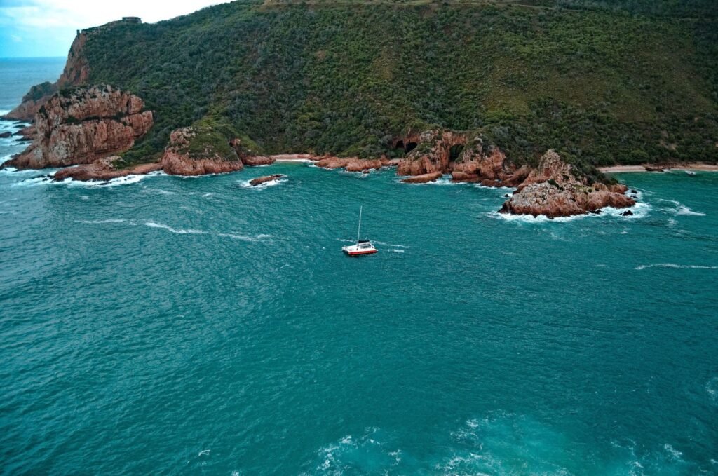 Zeilboot tussen de kliffen van de Knysna Heads