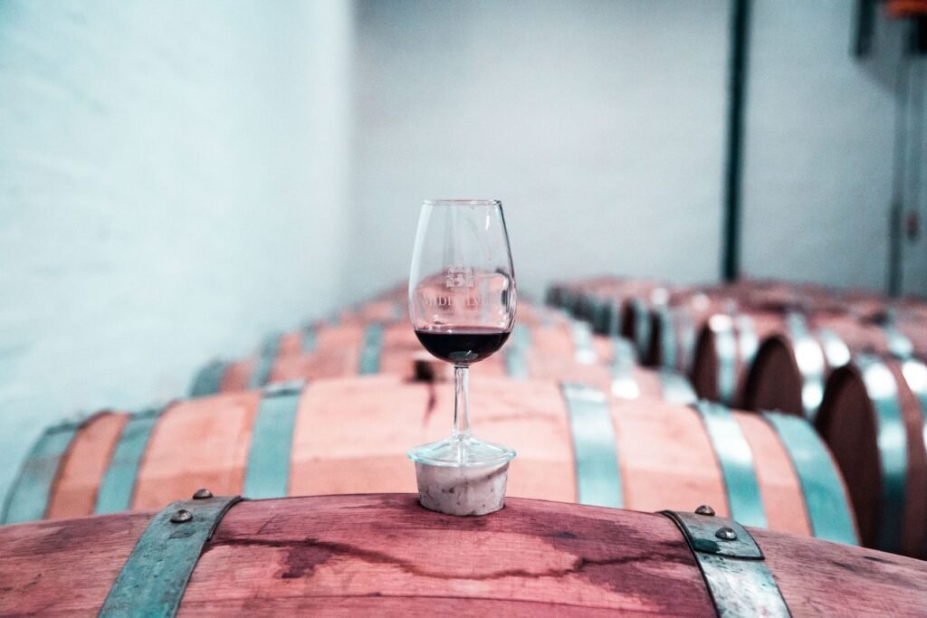 Glas rode wijn op een wijnvat in een wijnkelder
