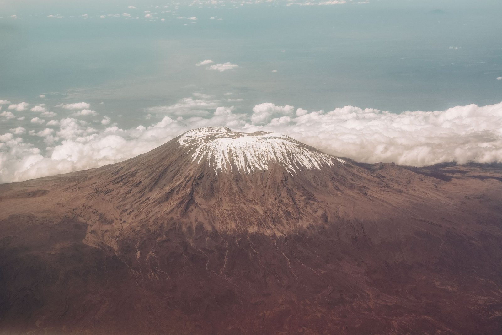 De top van de Kilimanjaro boven de wolken vanuit de lucht