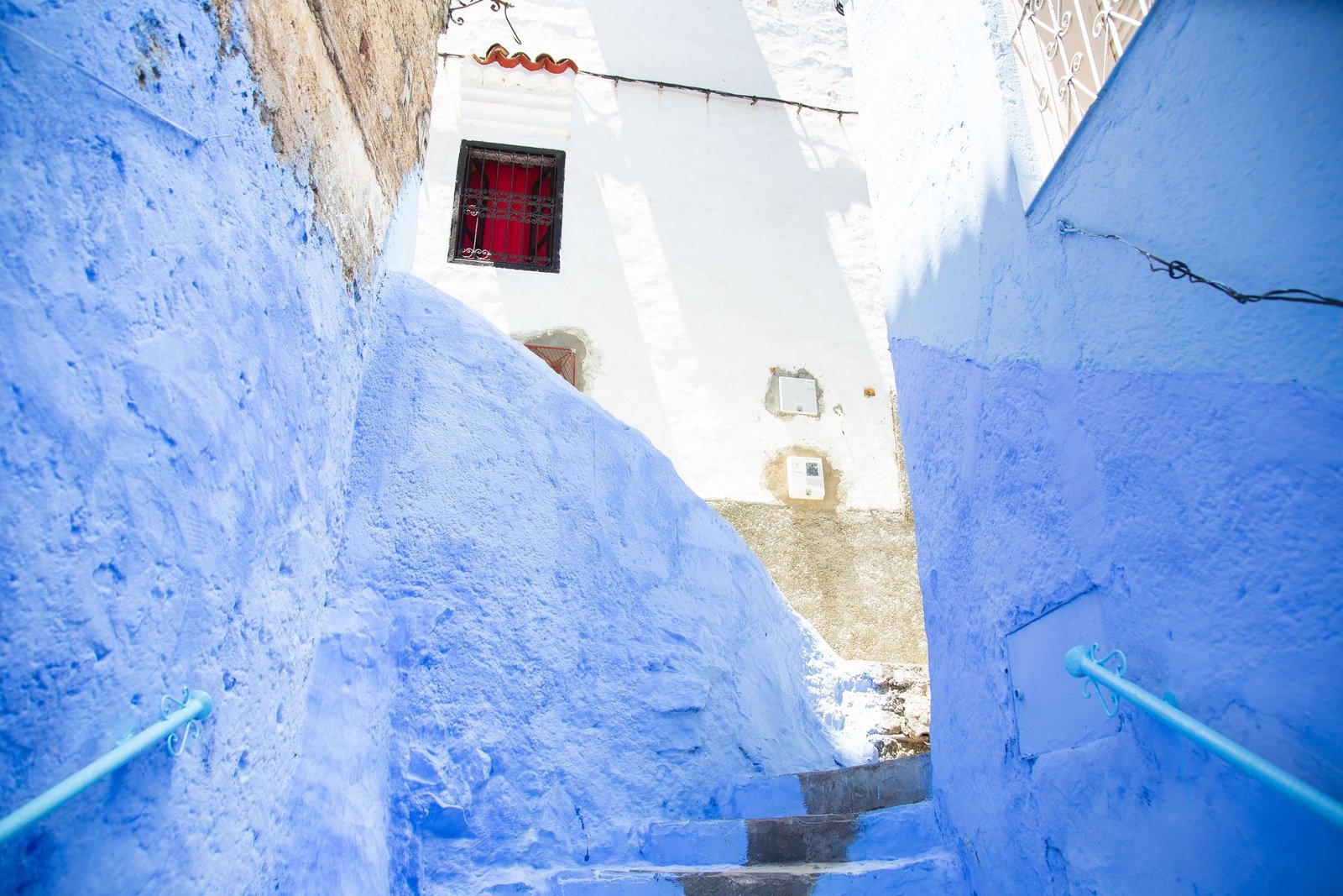 Blauwe trap tussen witte en blauwe muren in Chefchaouen