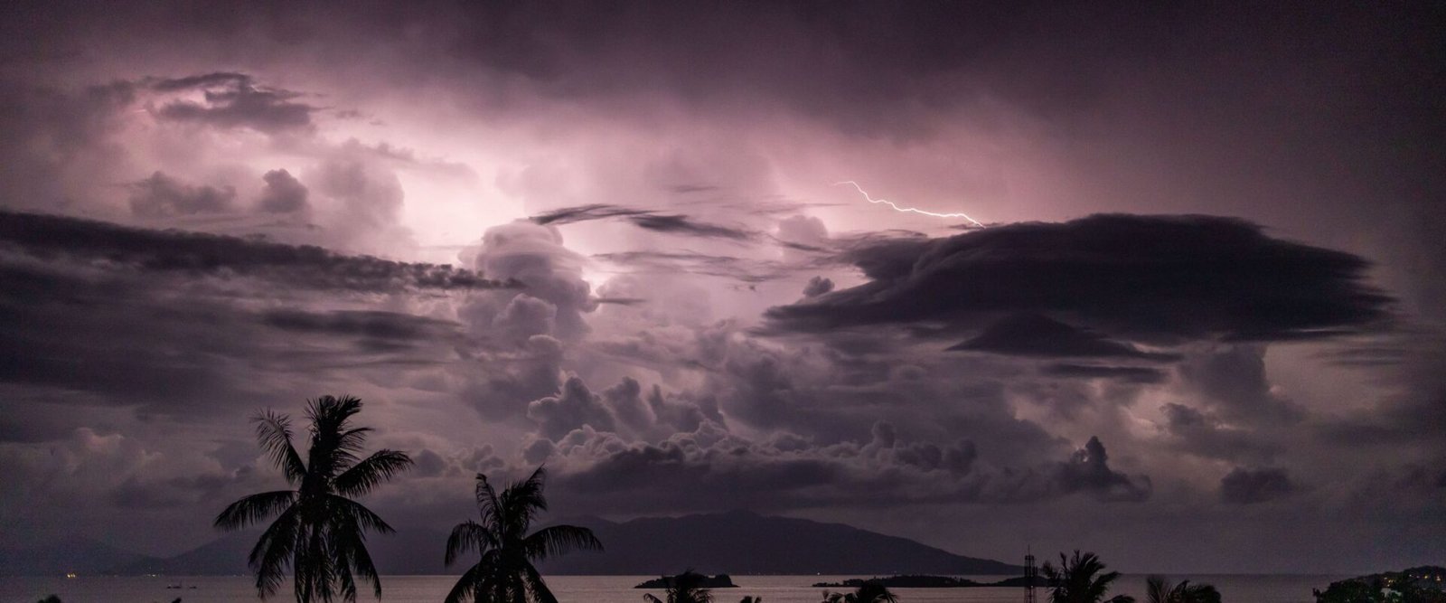 Onweer boven een tropische kust met palmbomen