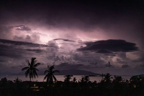 Onweer boven een tropische kust met palmbomen