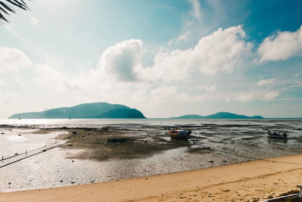 Strand op Phuket met boten en bergen