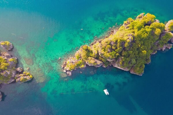 Rotsig eiland in turquoise water van bovenaf