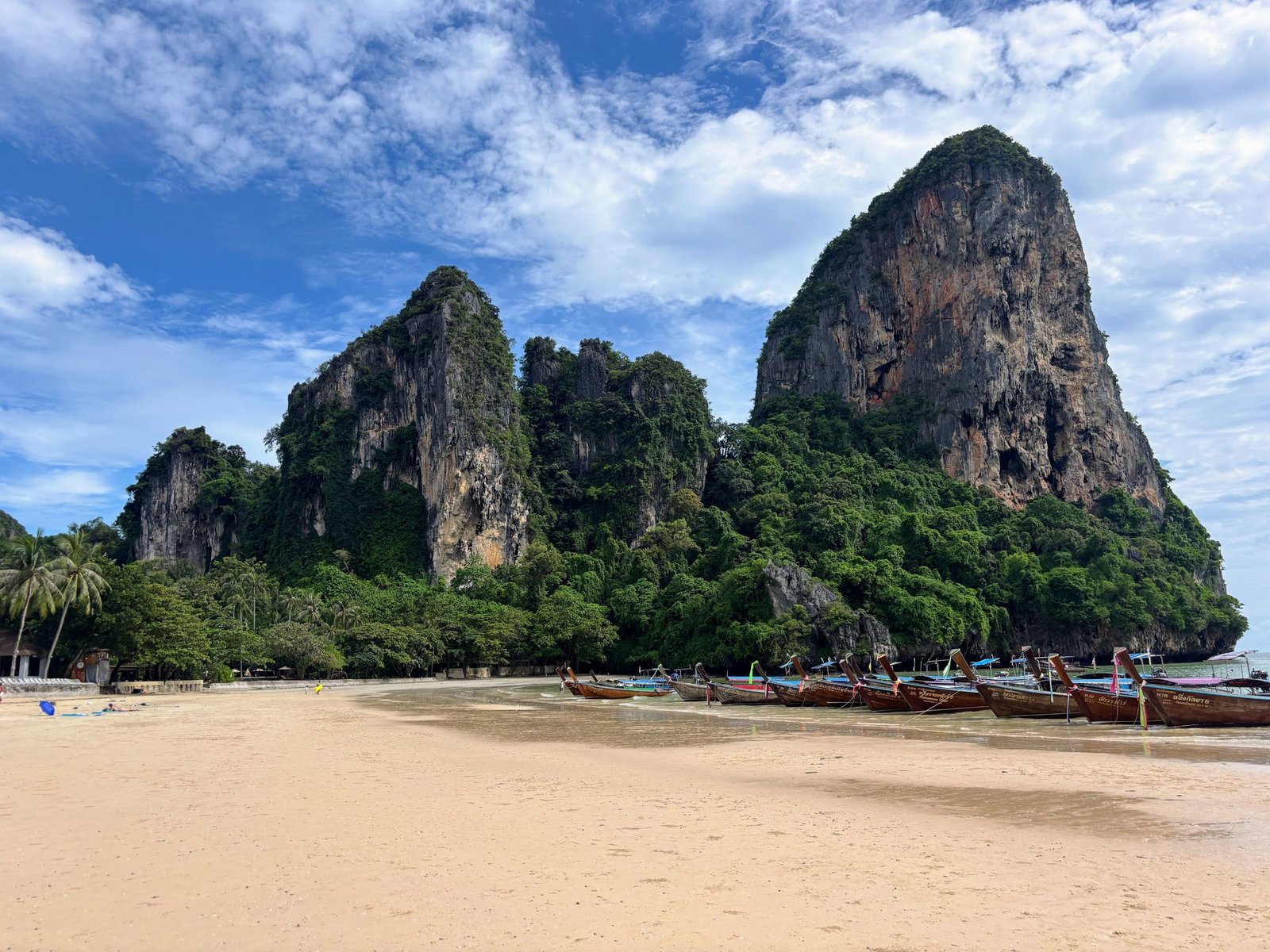 Railay Beach met kalksteenrotsen en longtailboten