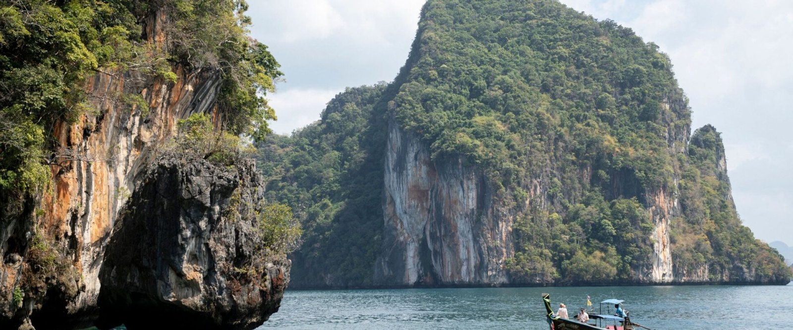 Kalksteenrotsen en een longtailboot bij Krabi